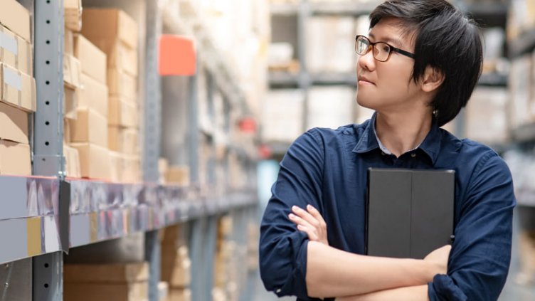 A man looking at the logistics stuff inside the warehouse