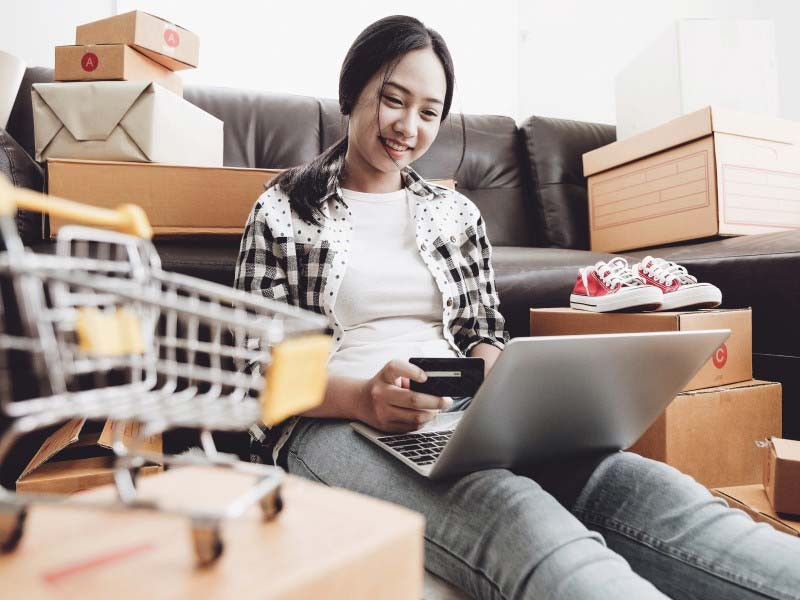 Woman holding her debit card and shopping online 