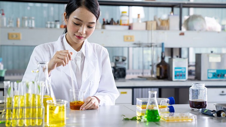 A lab specialist using a beaker and doing a test. 