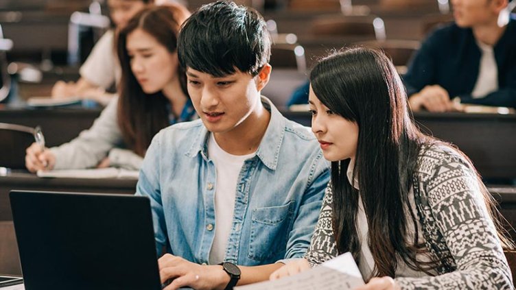 students discussing in-front of laptop