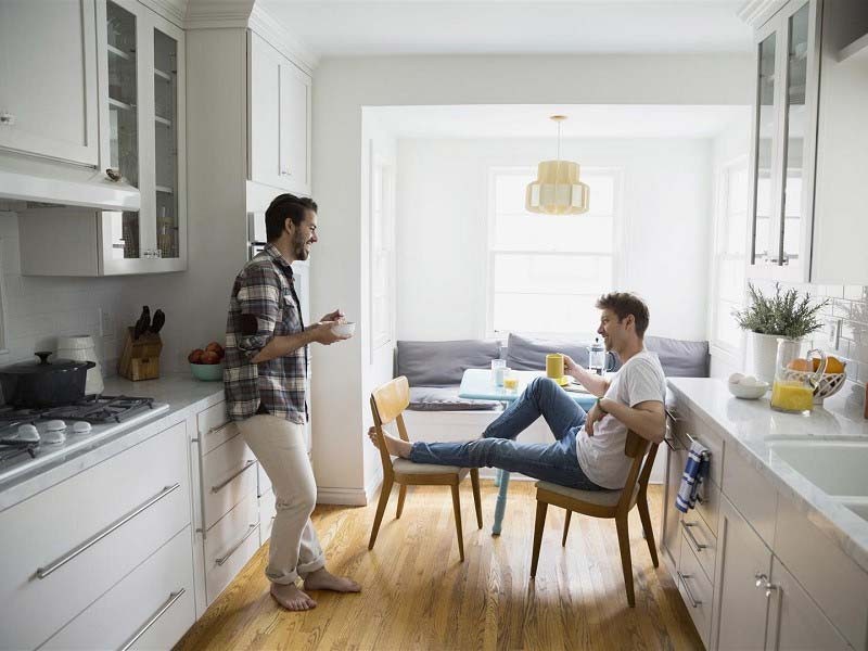 Two friends talking while having breakfast in the kitchen area