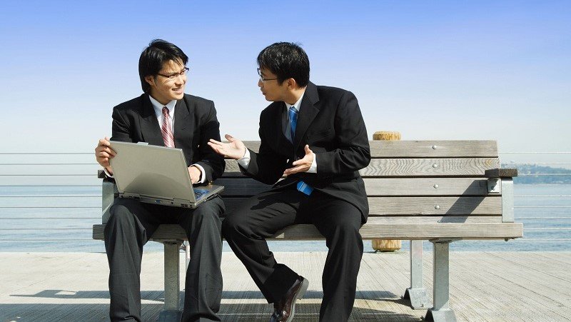 Two employees discussing something while sitting on the bench