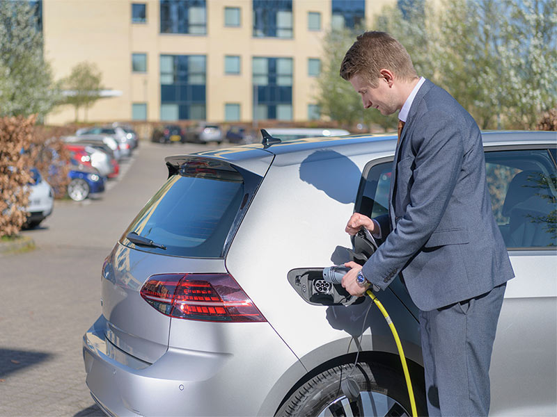 Man inserting an EV charger into an electric vehicle