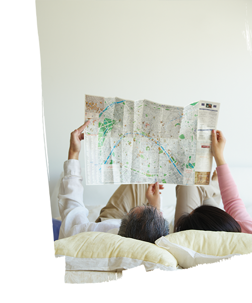 A couple looking into the map while laying down inside the hotel room